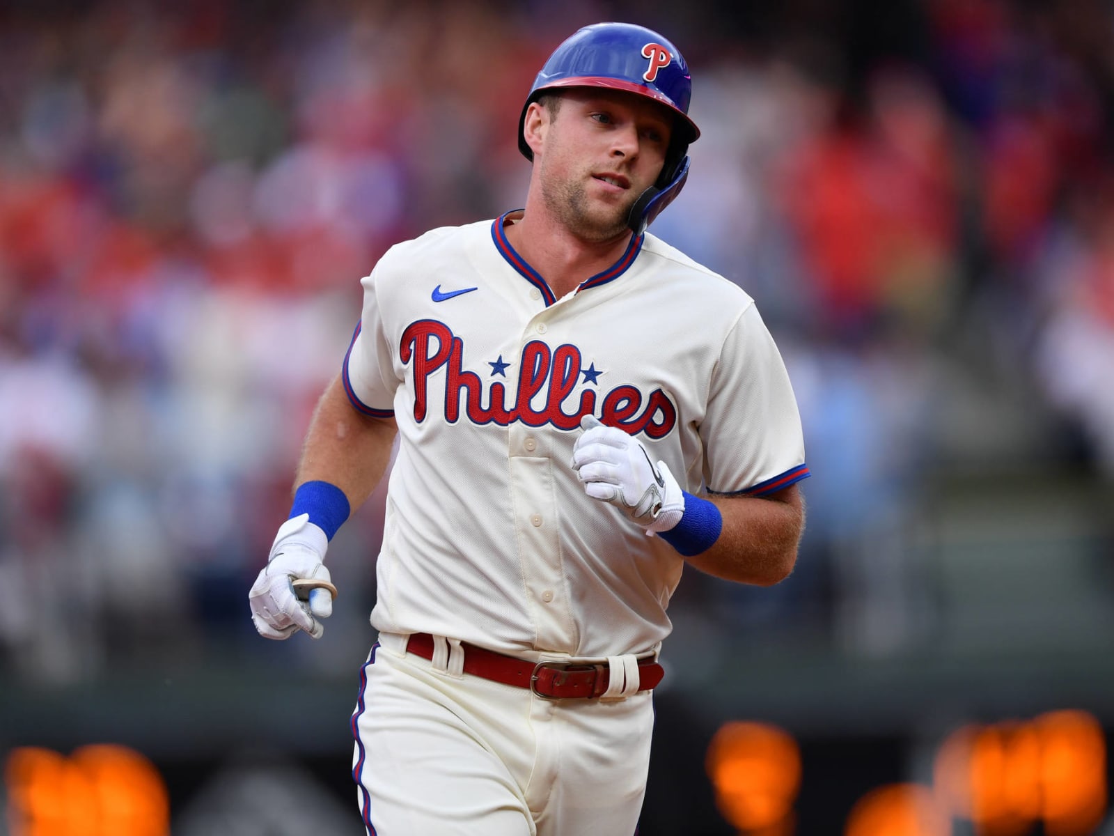 Philadelphia Phillies - Rhys Hoskins, wearing the cream Phillies uniform,  celebrating with the dugout after scoring a run.