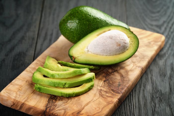 Premium Photo  Woman cutting avocado on cutting board to prepare breakfast