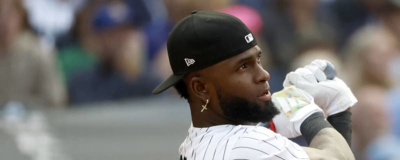 Chicago White Sox's Elvis Andrus, left, puts on the home run Southside  jacket and hat on Luis Robert Jr., right, after Robert hit a solo home run  against the Los Angeles Dodgers