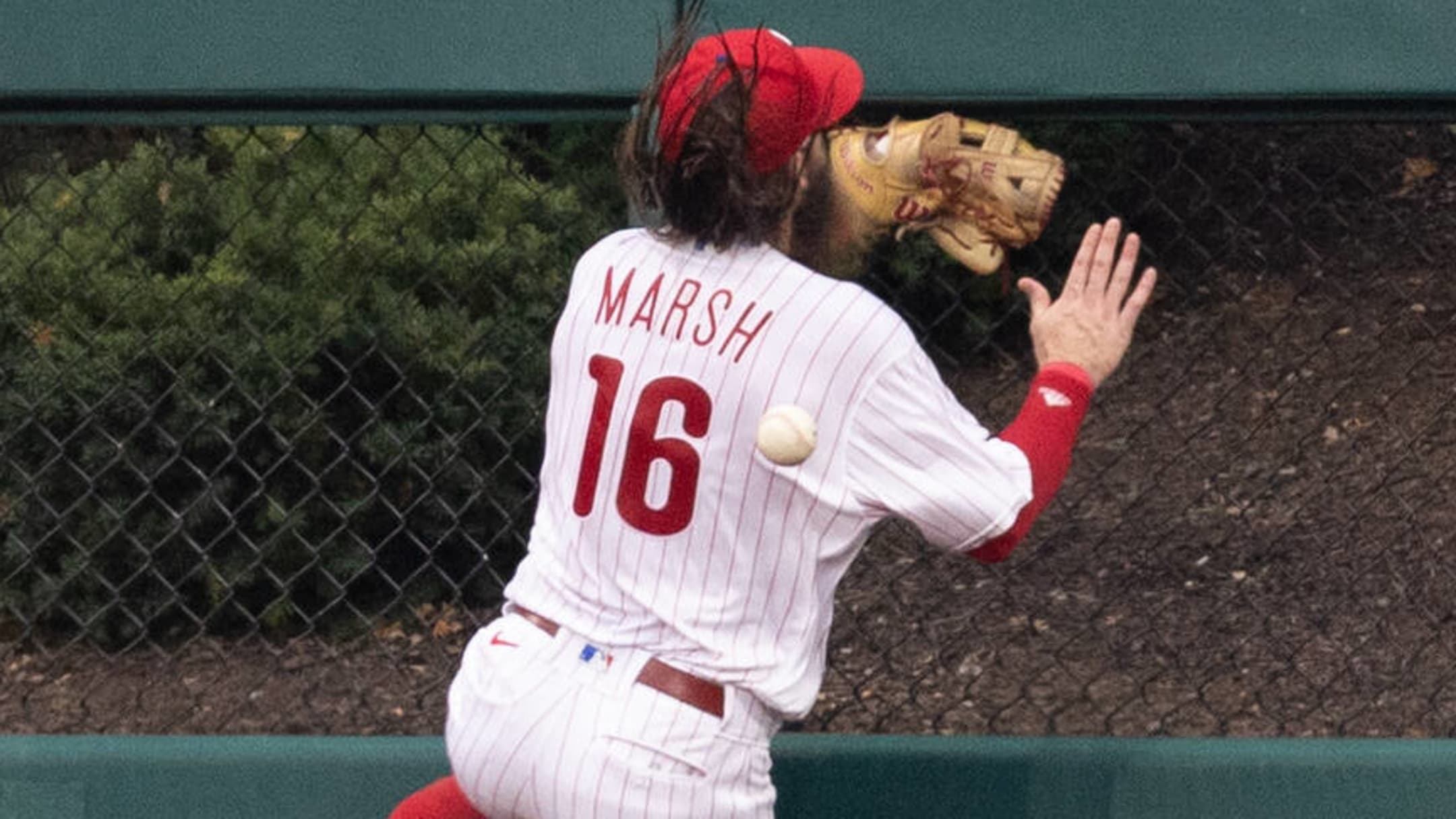 Philadelphia Phillies' Brandon Marsh takes off a batting glove