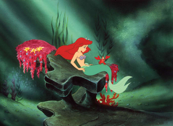 Ariel, a 18-year-old mermaid (later woman) with red short hair and blue  eyes who only wears purple bra. She lives in between underwater and town.  She is daughter of Sea King and