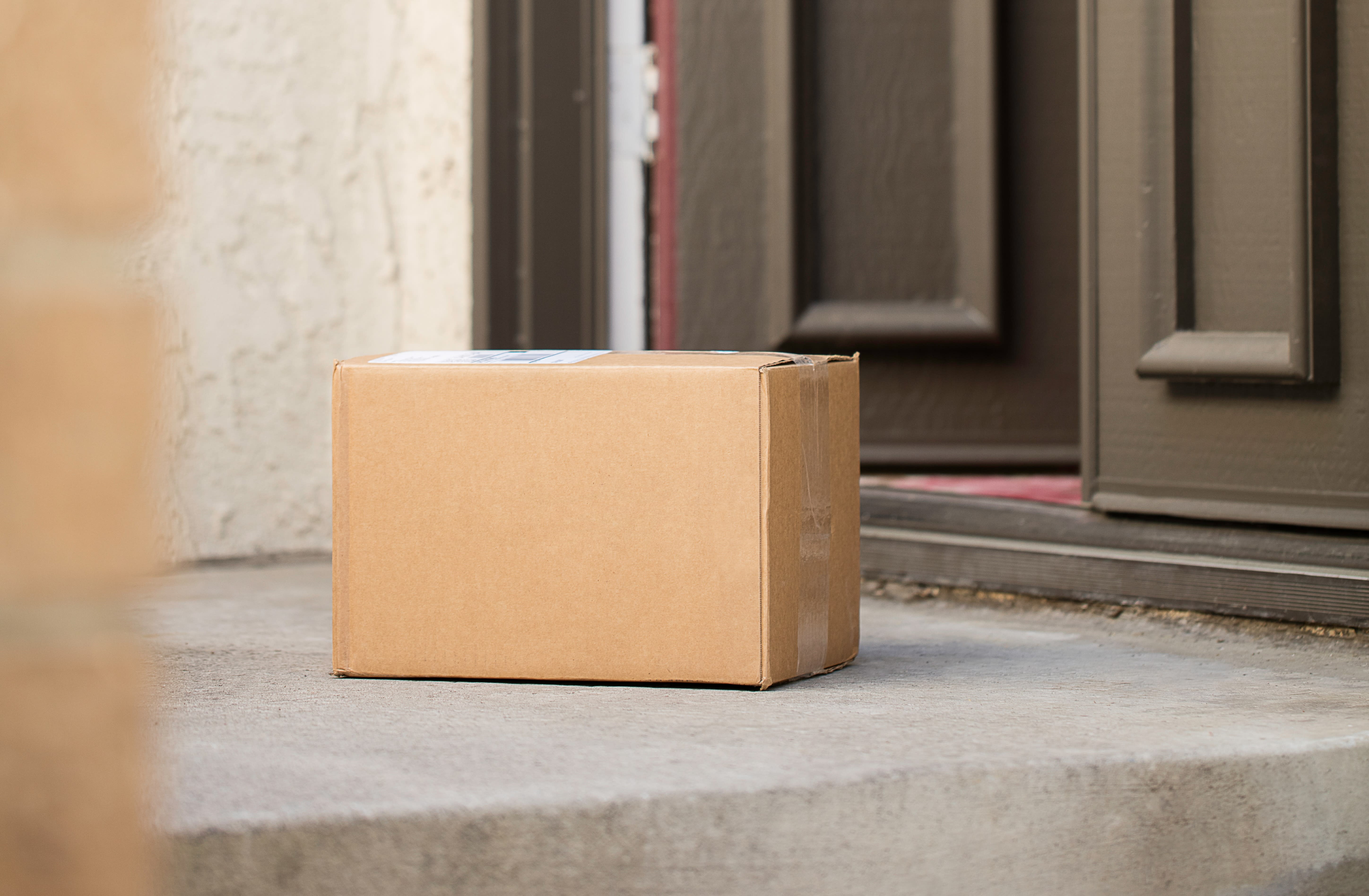 An image of a Cove migraine treatment box on a doormat, next to a pair of wellington boots and a plant.