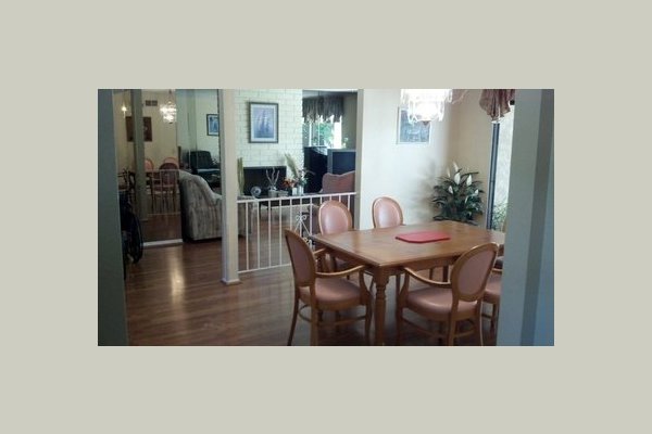 This is were we serve our delicious home cooked meals. In the back you will see one of two living rooms were residents can relax and socialize.