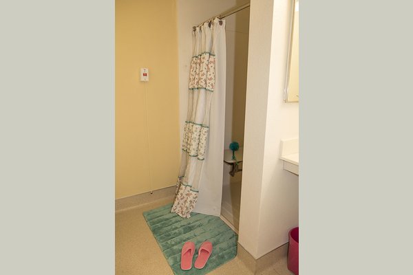 Large bathrooms with roll in showers, built in bench seats, handheld nozzle, handrails and emergency pull cord.