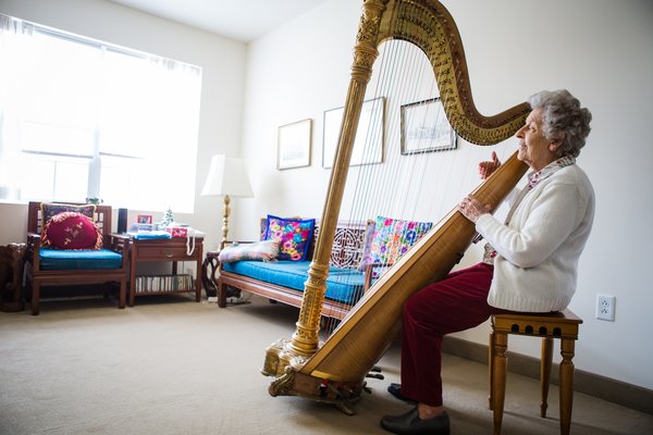 A Van Dyk Park Place resident places her harp in the comfort of her own apartment