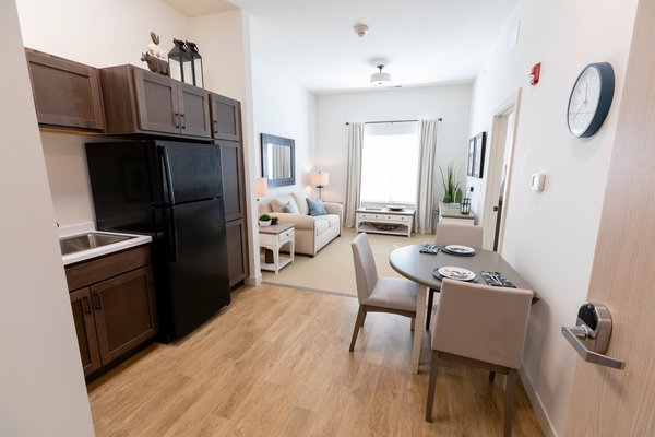 A look at the kitchen and living room in a one bedroom model room. On the carefree living and assisted living side of our community, we have studios, one-bedrooms, deluxe one-bedrooms and two-bedroom apartments. 