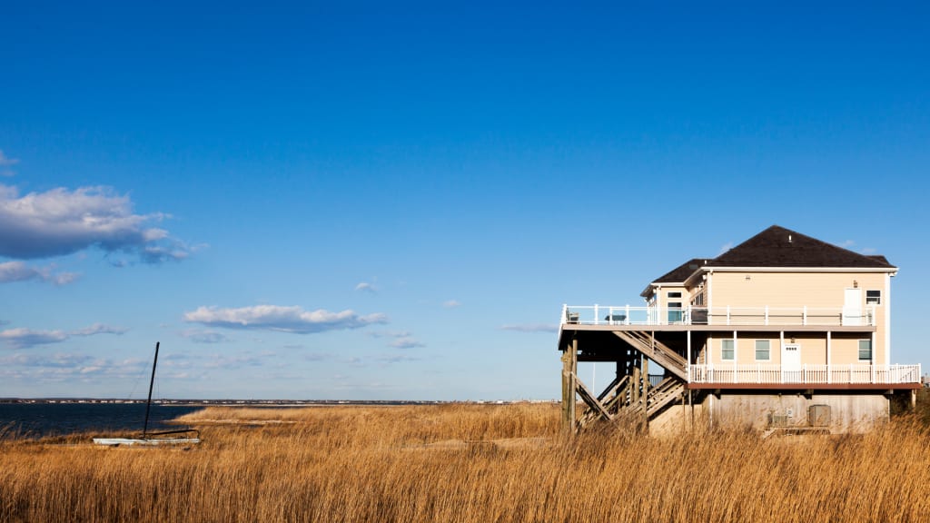 A vacation home in need of some vacation home cleaning sits on a marsh by the ocean