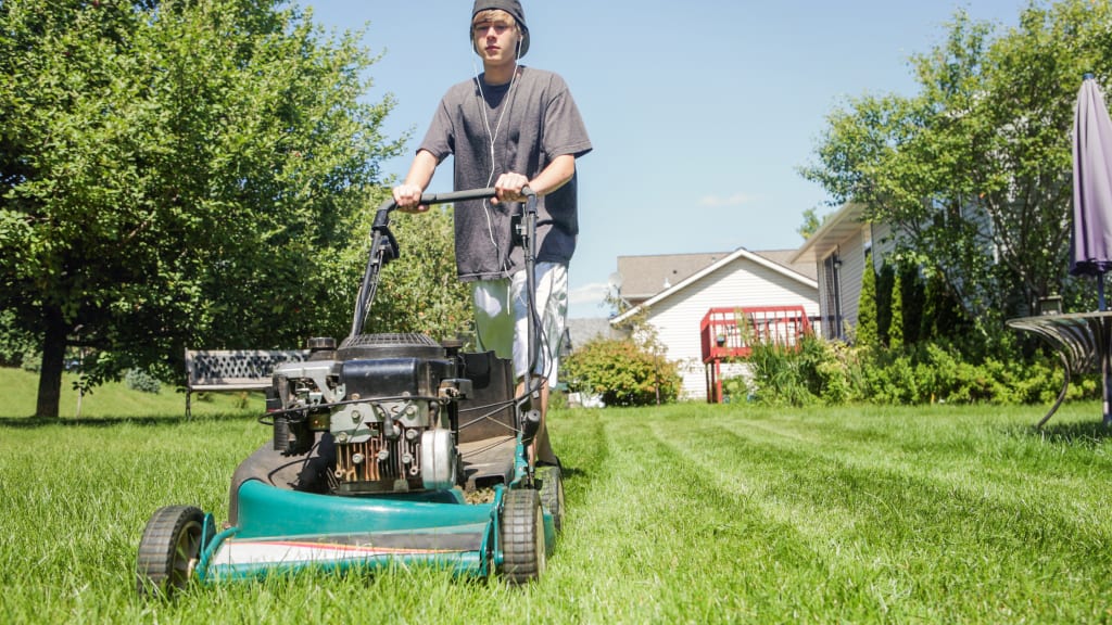 A teenager mows the lawn - one of many age appropriate chores for kids to do