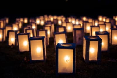 A series of boxed candles sit on a ground