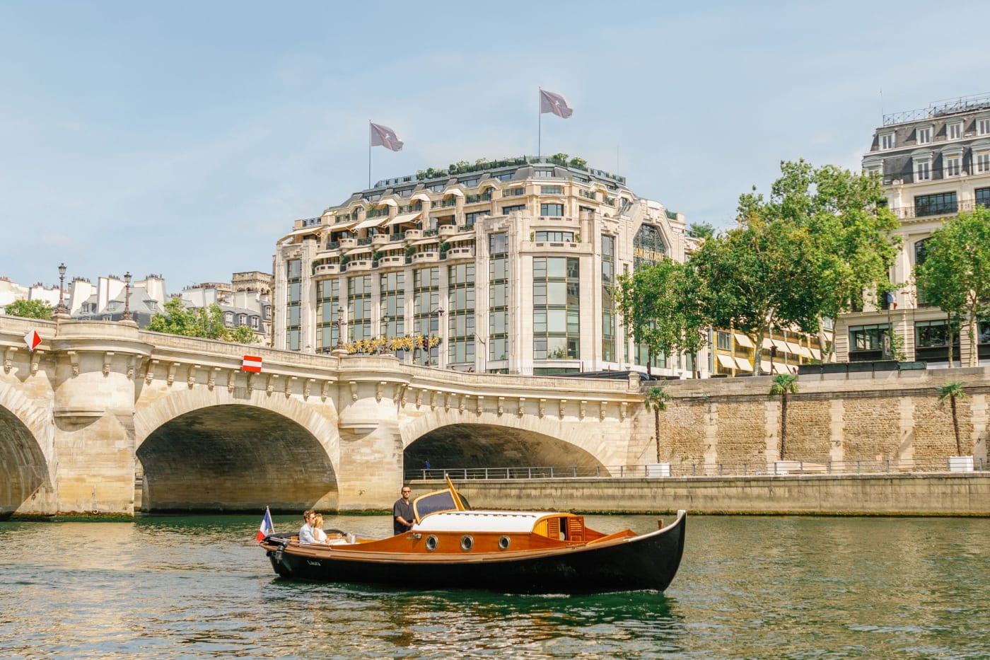 Barco de madera en el Sena frente al Pont-Neuf y la fachada de Cheval Blanc Paris