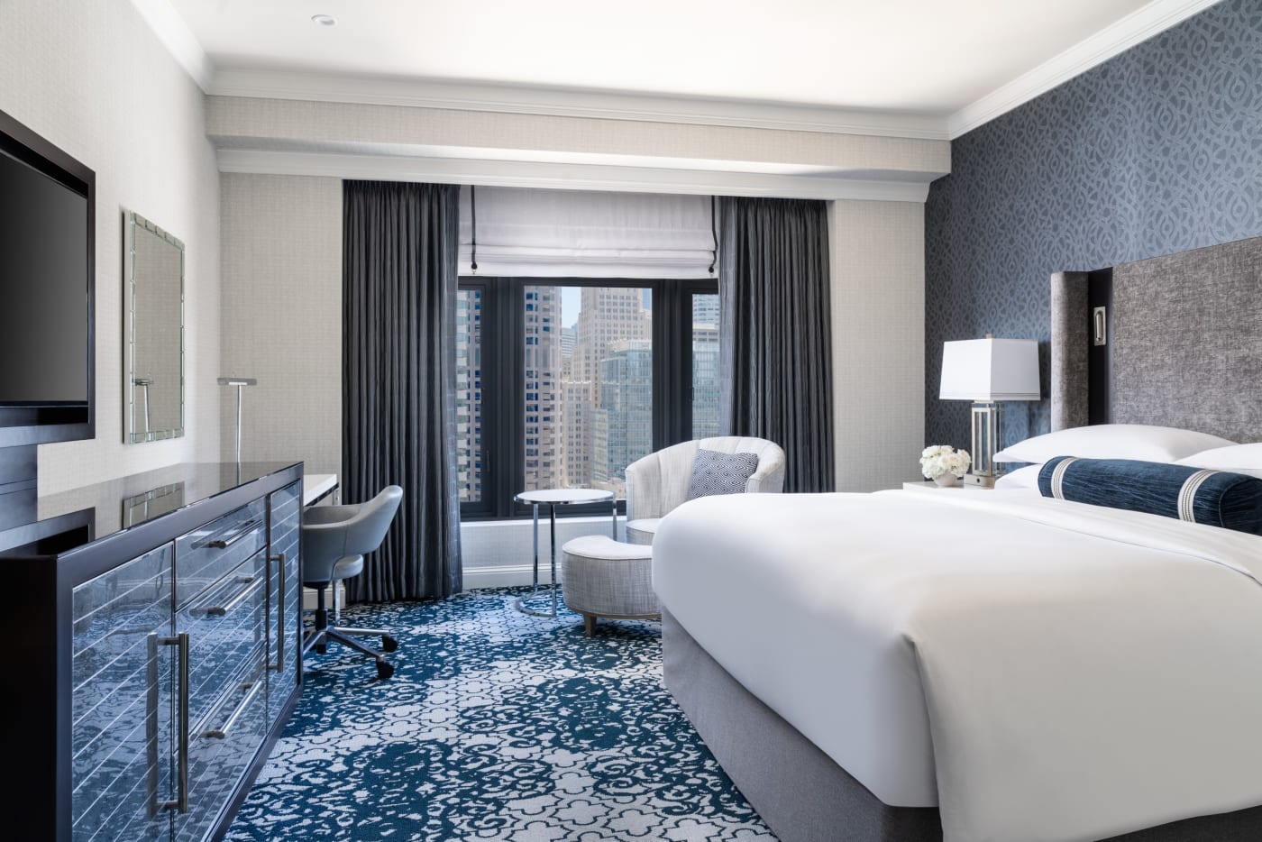 Quarto com cama king-size do Ritz-Carlton San Francisco, carpete azul e vista para a cidade