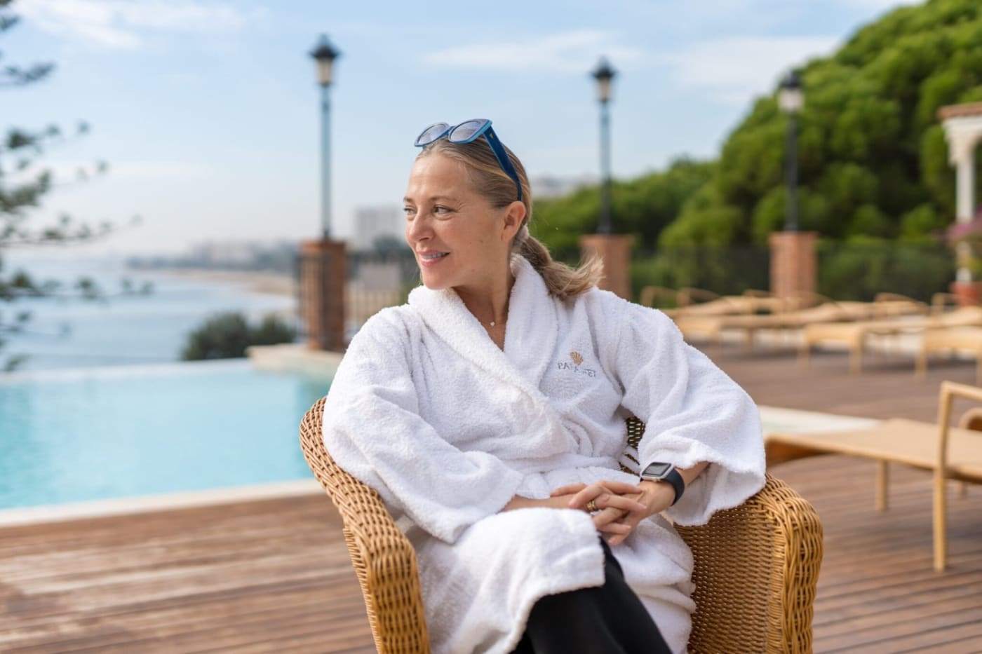Una huésped en albornoz en la terraza de la piscina panorámica de Palasiet, frente al mar