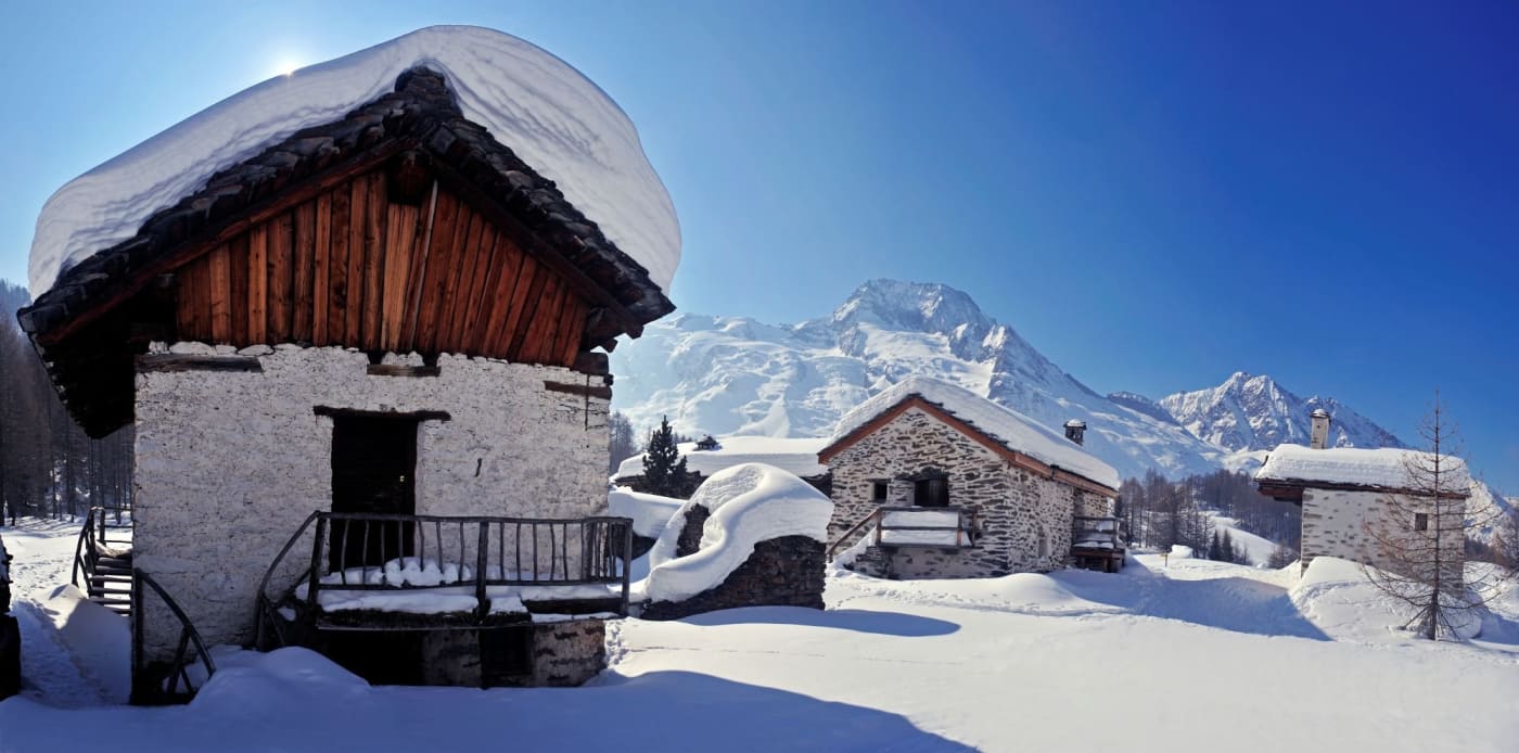 Der geschützte Weiler Le Monal im Schnee, Chalets aus Stein und Holz gegenüber dem Mont Pourri, in Sainte-Foy-Tarentaise