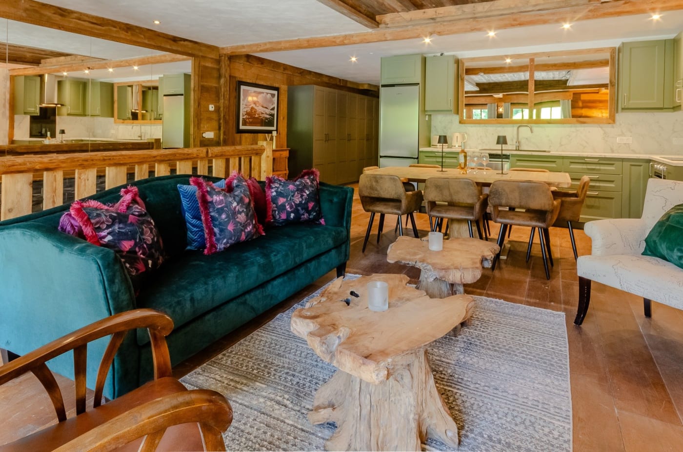 Der Wohnbereich eines Black-Diamond-Chalets mit grünem Sofa und offener Küche, in Sainte-Foy-Tarentaise