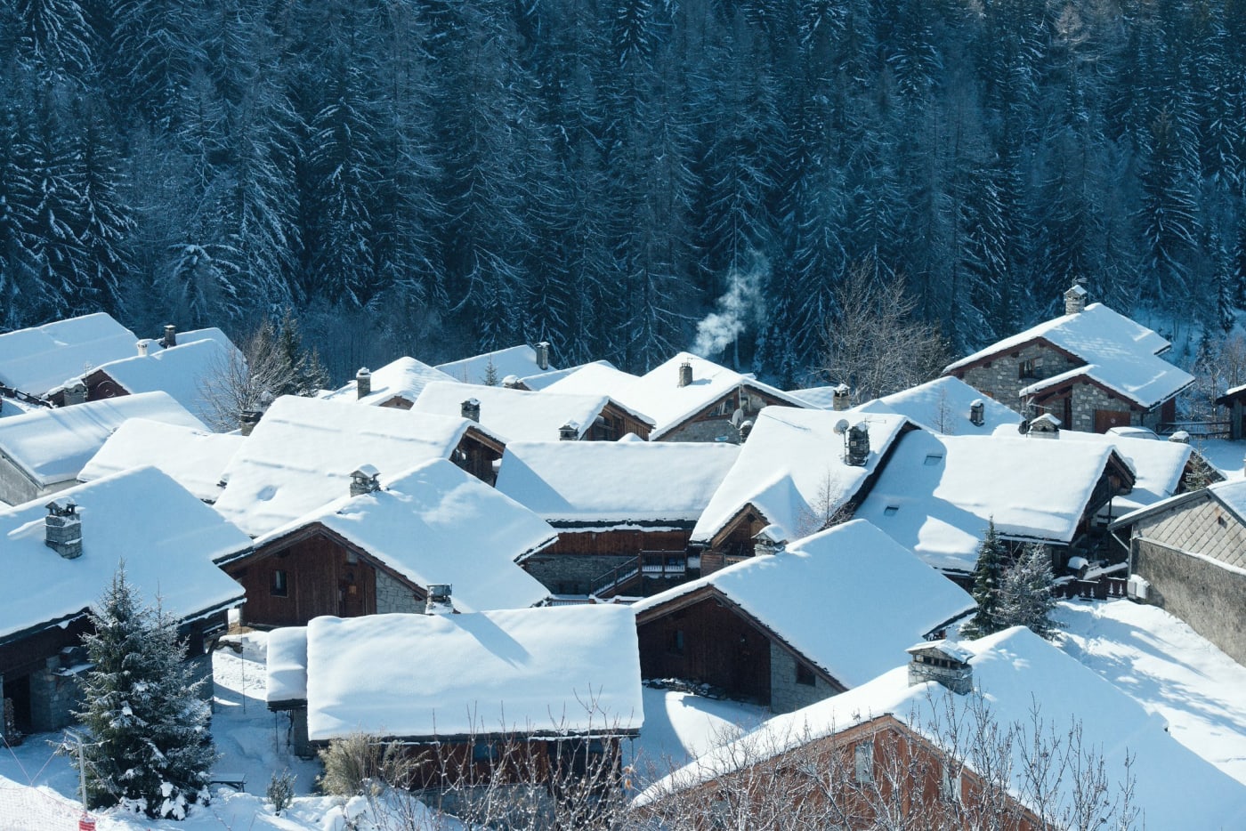 Die verschneiten Dächer eines Chalet-Weilers im Wald, in Sainte-Foy-Tarentaise
