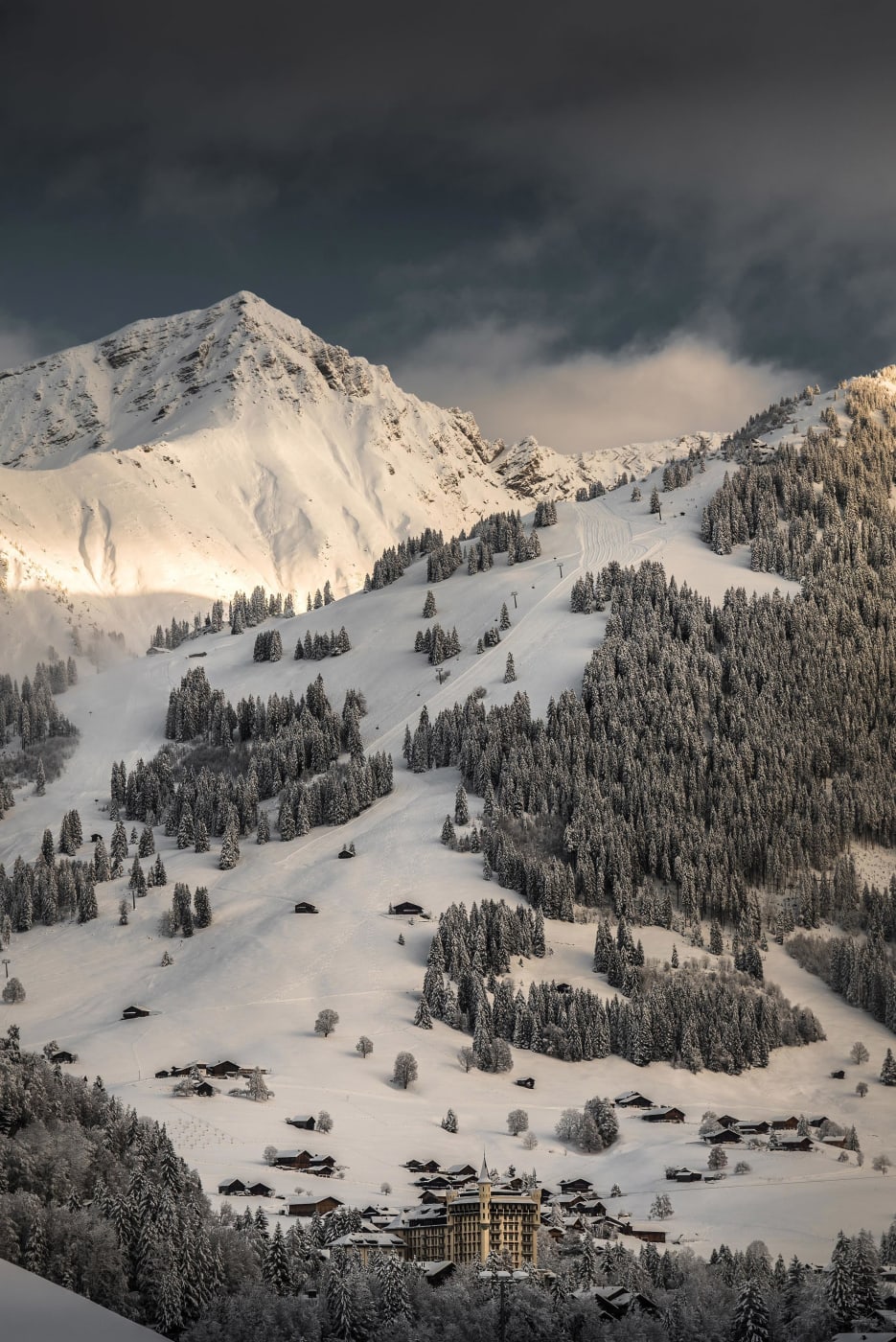 Le Gstaad Palace au pied des sommets enneigés du Saanenland, en hiver