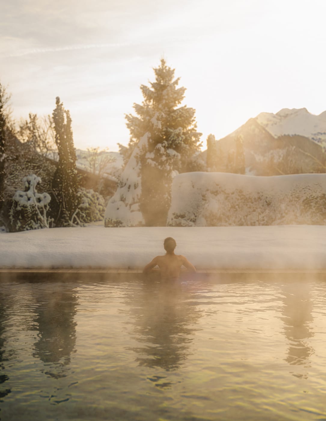 La piscine extérieure chauffée du Six Senses Spa de The Alpina Gstaad, dans la vapeur d'un matin d'hiver