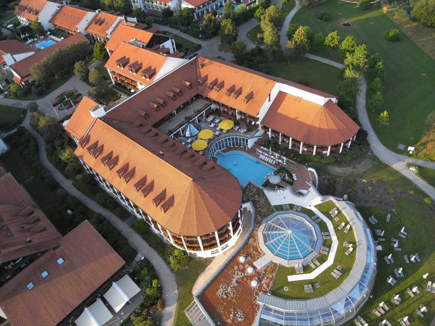 Vue aérienne de l'Ensana Fürstenhof à Bad Griesbach, ses toits rouges, sa coupole vitrée et ses piscines thermales