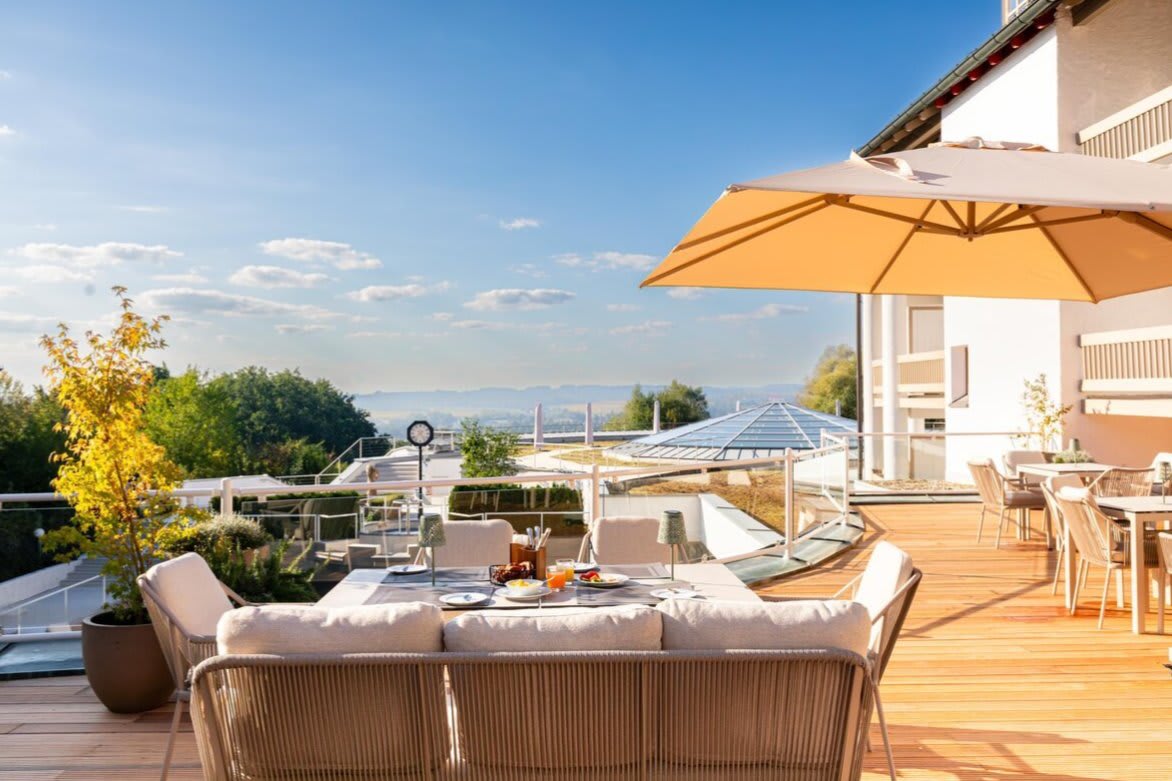 La terrasse de l'Ensana Fürstenhof, salon extérieur et parasol face à la campagne de Basse-Bavière