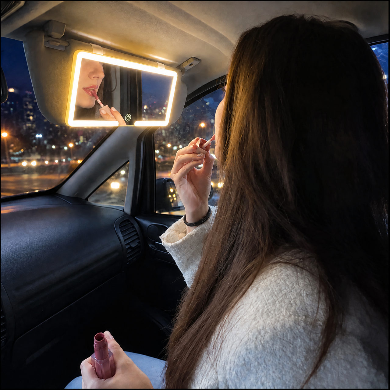 Mujer maquill&aacute;ndose frente al espejo LED para visera con la luz encendida
