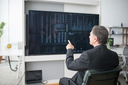 gestionnaire de flotte consultant un tableau de bord télématique sur écran d'ordinateur dans un bureau d'exploitation, lumière naturelle, ambiance concentrée et professionnelle