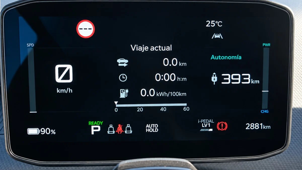 Primer plano de la pantalla digital del cuadro de instrumentos de un vehículo eléctrico encendido, mostrando datos del viaje actual, noventa por ciento de batería y trescientos noventa y tres kilómetros de autonomía.