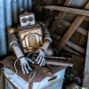 A photo of a steampunk robot sitting in the corner of a dusty shed. It is covered in spider webs, dust, and is partially draped in a sheet. It looks a little rusty, but also looks like it could still work if given a little care.