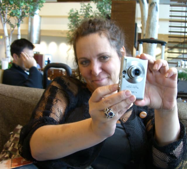 Molly loved to take pictures. Here she’s sitting on a couch taking a picture of me taking a picture of her. It was a favorite pastime of ours. She was wearing a black shirt with a laced coverup and has a beautiful smile on her face. This was probably at the Hampton Inn near the Convention Center as we were there for SXSW.