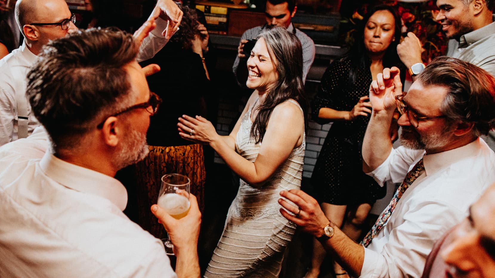 Meredith in the center of a dance circle grinning ear to ear, surrounded by smiling, energetic friends