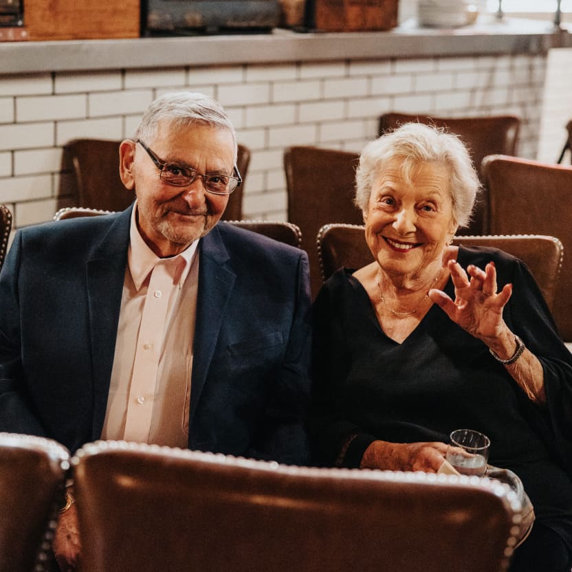 Aunt Joan and Uncle Mort sitting in their seats, waiting for the ceremony to start, waving to the camera