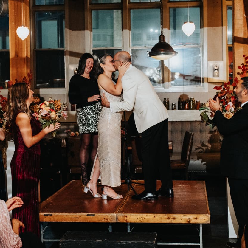 Andrew & Meredith kissing on the big stage at the celebratory conclusion of the ceremony