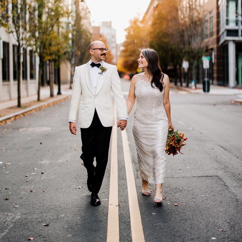 Andrew & Meredith, walking hand in hand down the middle of an empty street in Boston, smiling at each other