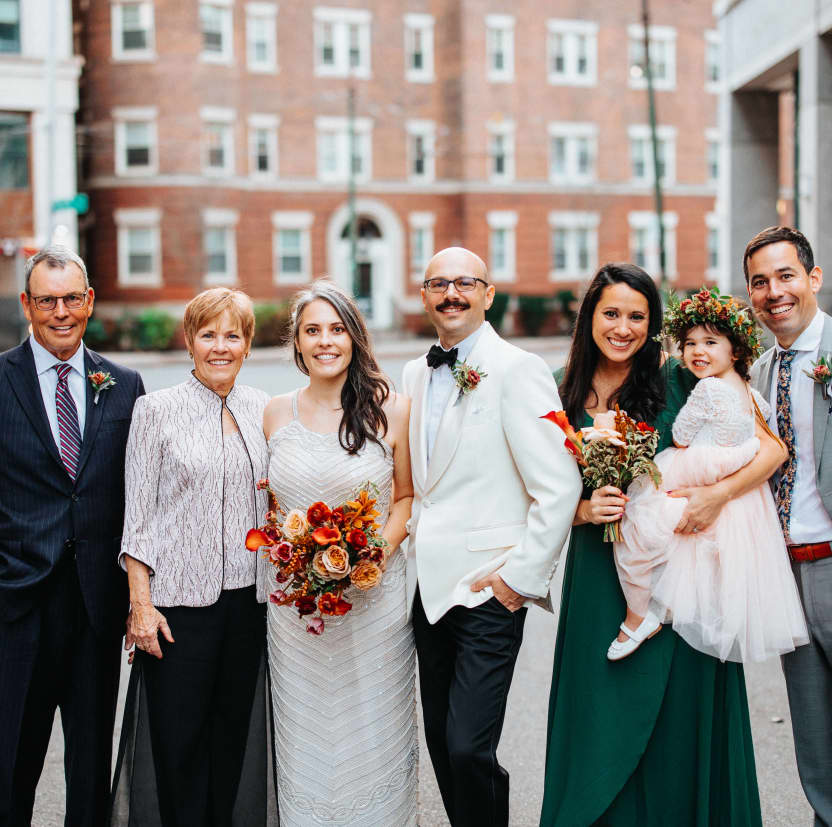 Andrew & Meredith and her parents, brother, sister, and niece, posing for a portrait in the street