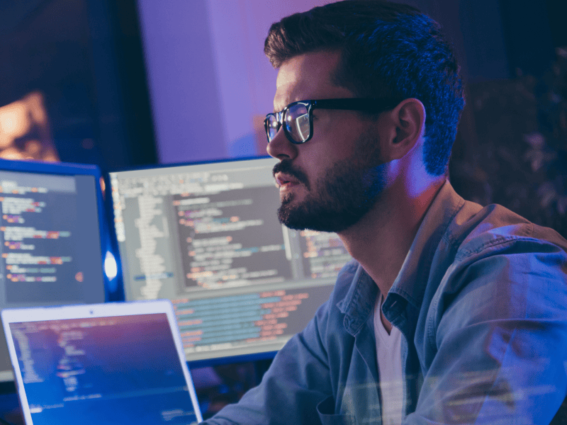 Person with multiple screens of code