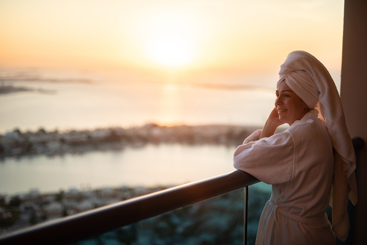 Woman enjoying sunrise from hotel balcony in Spain