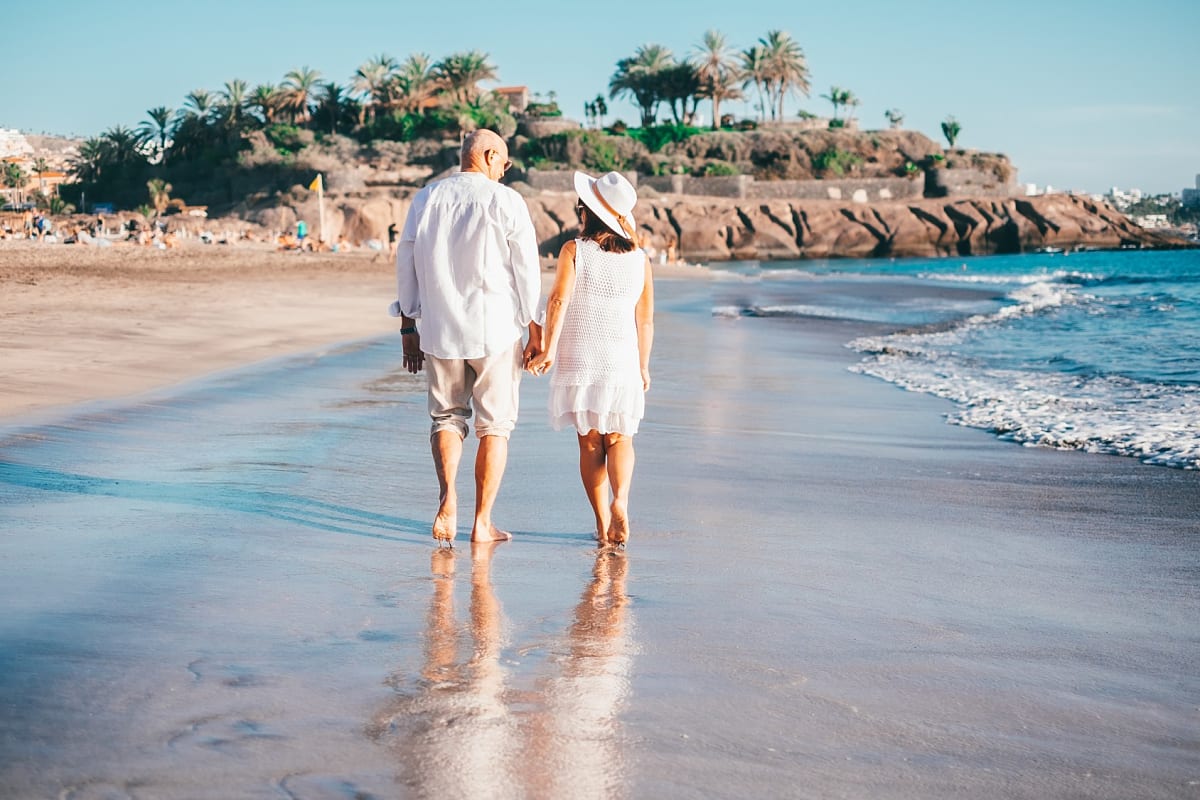 Couple walking on the beach at sunset