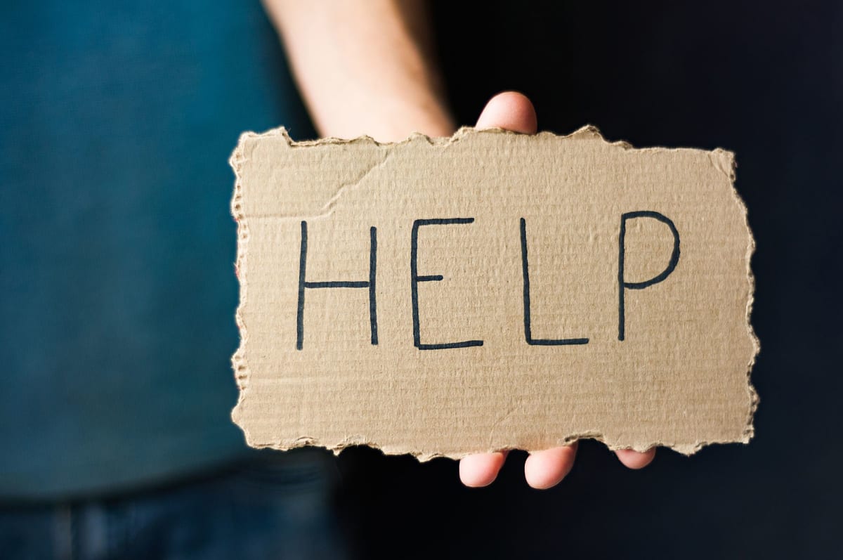 Person holding help sign