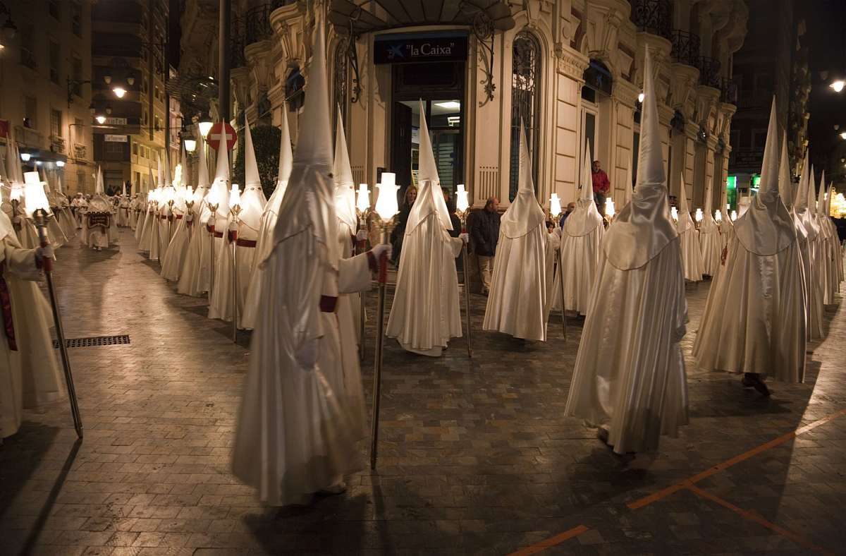 Nazarenos in traditional robes during Semana Santa procession in Cartagena, Spain