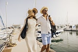 Pareja de jubilados caminando cerca del mar en un paseo soleado