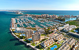Vista aérea del puerto deportivo en la costa de España, que representa mercados de alta demanda como la Costa Blanca y la Costa del Sol.