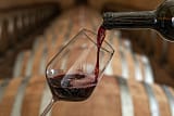 Rotwein wird im Keller ins Glas gegossen