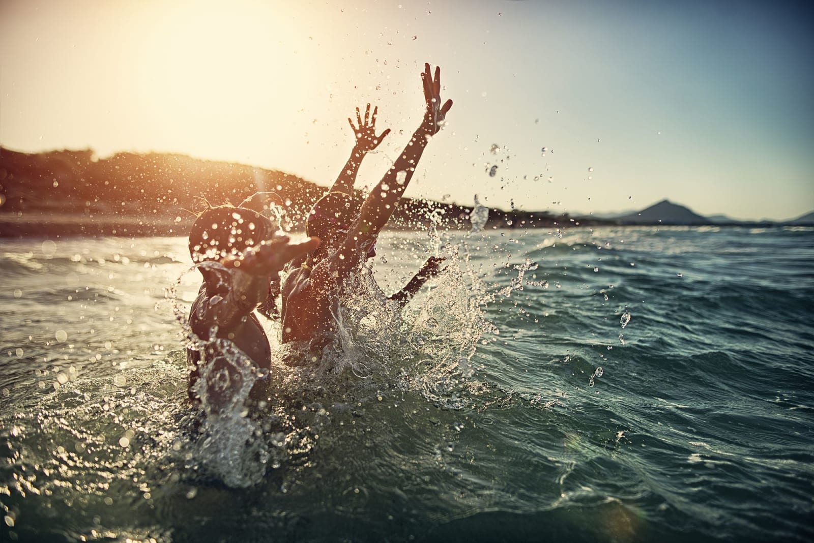 Children splashing in the summer sea in Spain