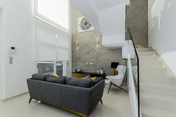 Double-height living room with staircase and large windows