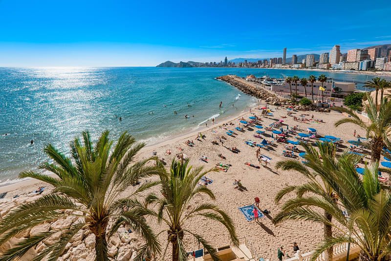 Bustling Benidorm beach with tourists and restaurants