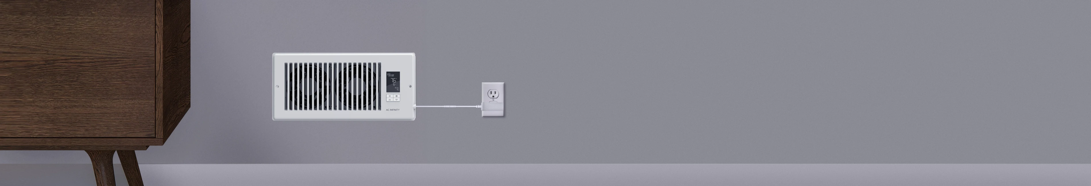 White Airtap register booster fan installed in a wall and plugged into a standard power outlet.