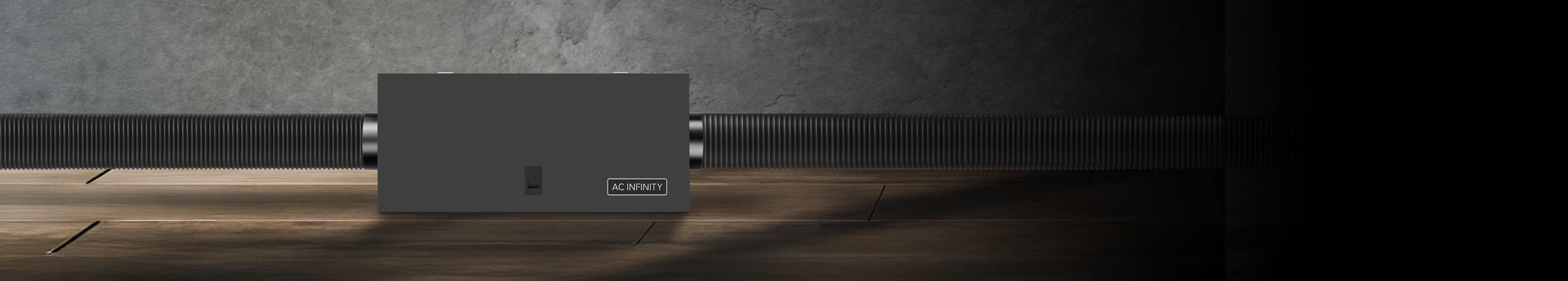 AC Infinity metal air filter box connected to flexible black ducting on a wooden workshop floor.