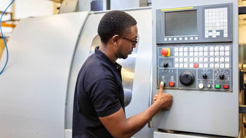 Man with glasses pressing a button on a machine