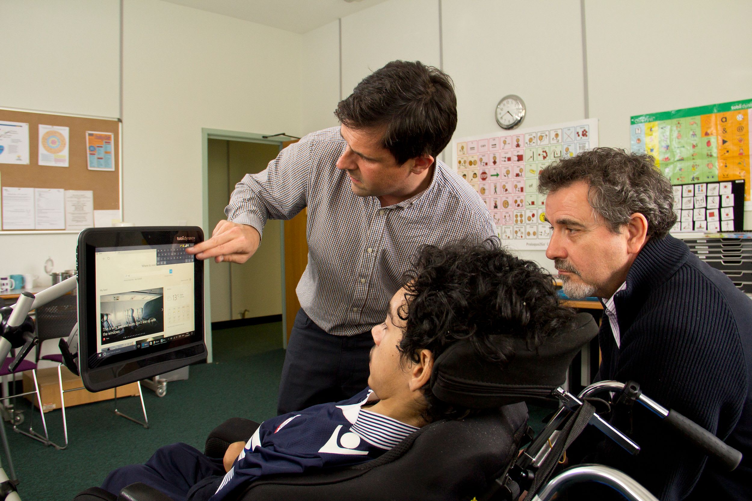 An Ace Centre staff member showing a client how to use their device