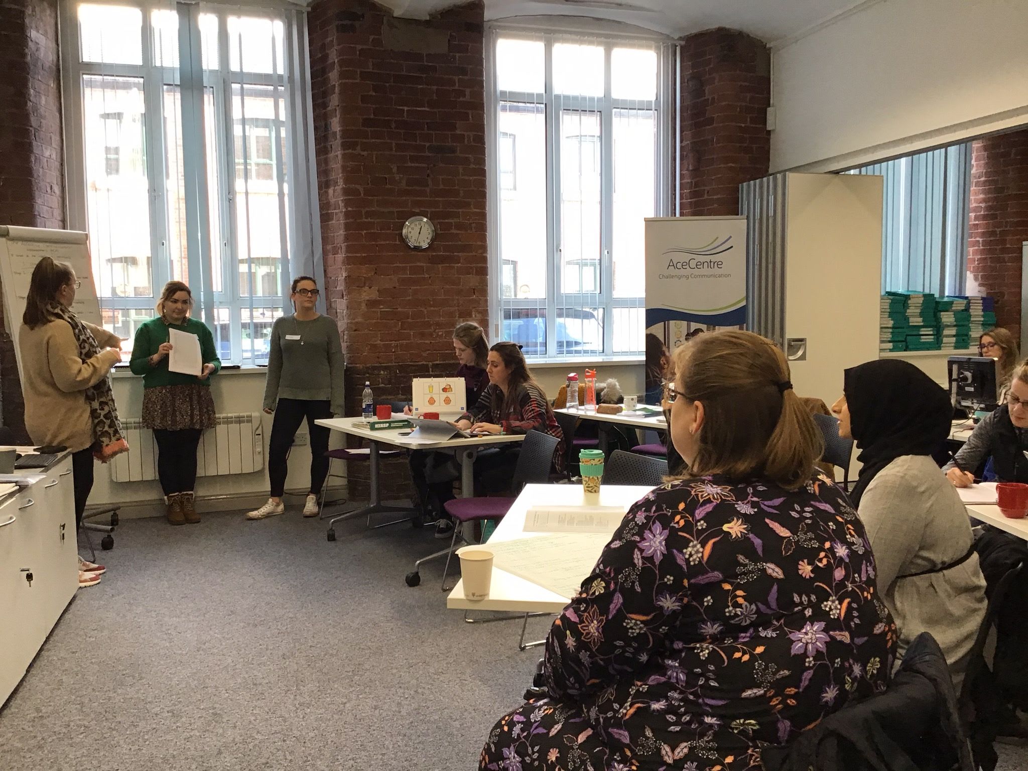 A room with people presenting at the front