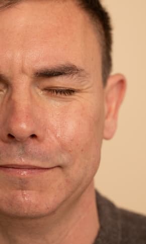 A person, eyes closed, crying.